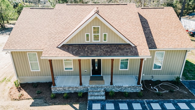 view of front of property with roof with shingles, covered porch, and board and batten siding