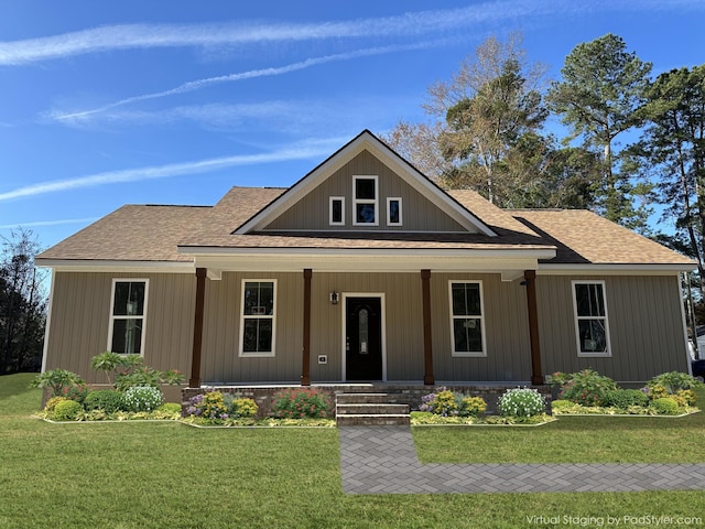 view of front facade featuring a shingled roof, a porch, and a front lawn