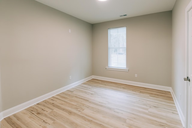 unfurnished room with baseboards, visible vents, and light wood finished floors