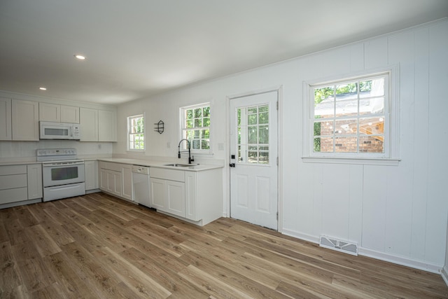 100 Colonial Dr, Goose Creek, SC 29445 - kitchen with a sink, white appliances, light wood-type flooring, visible vents, and light countertops