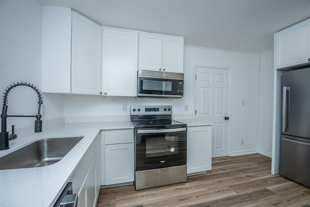 100 Colonial Dr, Goose Creek, SC 29445 - kitchen featuring a sink, light wood finished floors, white cabinetry, light stone countertops, and appliances with stainless steel finishes
