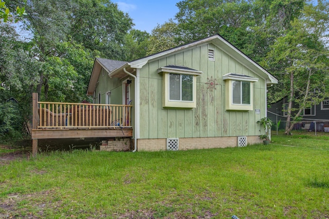 2702 Decatur St, North Charleston, SC 29405 - view of side of home featuring a deck, a lawn, crawl space, board and batten siding, and a shingled roof