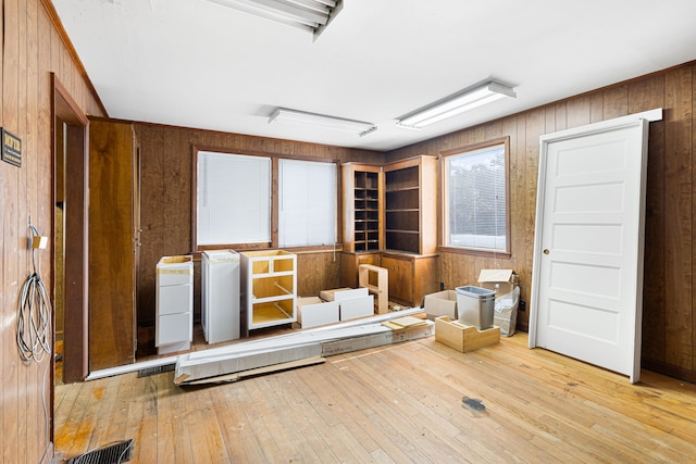 misc room with light wood-type flooring and wood walls