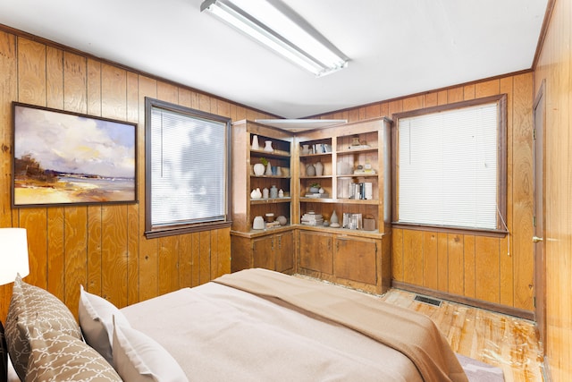 bedroom with hardwood / wood-style flooring and wooden walls