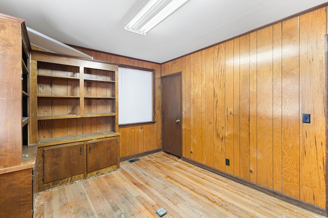 empty room featuring light hardwood / wood-style floors and wooden walls