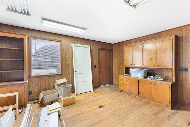 kitchen featuring light wood-type flooring and wood walls