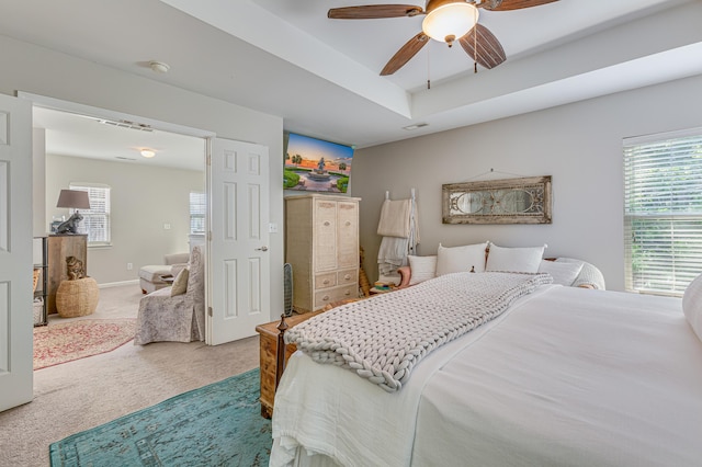 carpeted bedroom featuring multiple windows and ceiling fan
