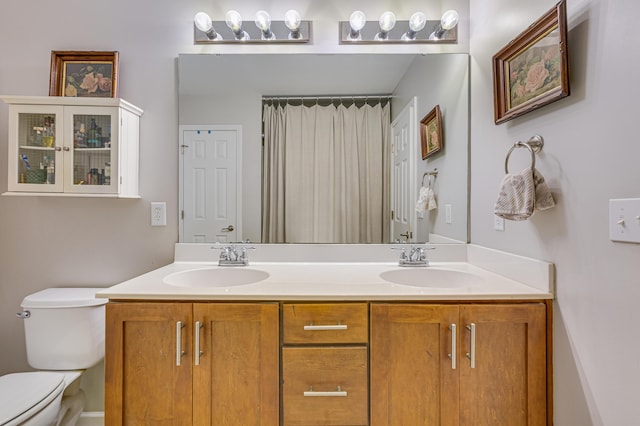 bathroom with toilet and double vanity