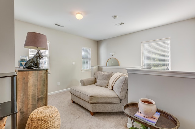 living area with light colored carpet and baseboards