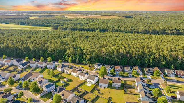 aerial view of property's location with a forest and nearby suburban area