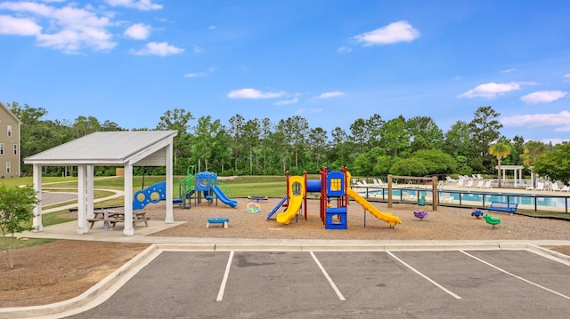 community jungle gym with a swimming pool and view of scattered trees