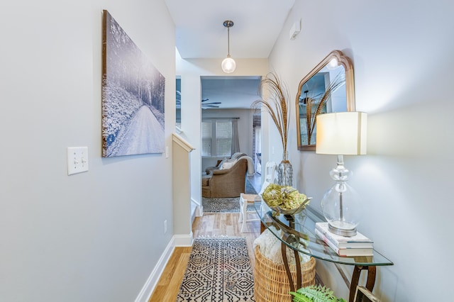 hallway with wood finished floors and baseboards