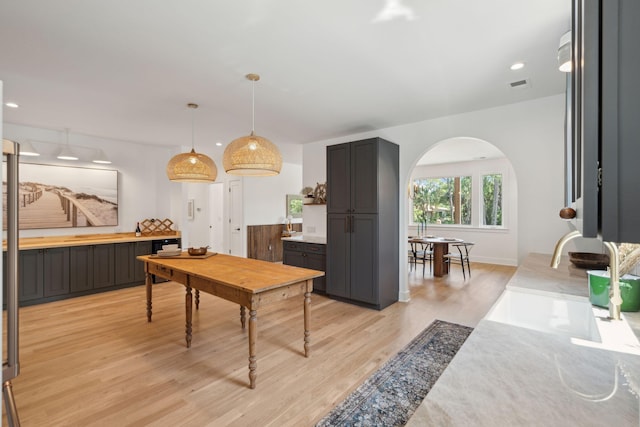 1012 E Erie Ave, Folly Beach, SC 29439 - kitchen featuring arched walkways, light wood finished floors, light countertops, hanging light fixtures, and recessed lighting