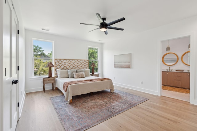 1012 E Erie Ave, Folly Beach, SC 29439 - bedroom featuring light wood-style floors, baseboards, connected bathroom, a ceiling fan, and a sink