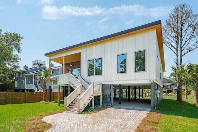 1012 E Erie Ave, Folly Beach, SC 29439 - view of front of home with a carport, ceiling fan, stairs, board and batten siding, and decorative driveway