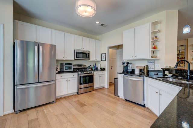 1231 Wild Olive Dr, Mount Pleasant, SC 29464 - kitchen with appliances with stainless steel finishes, a sink, open shelves, light wood-style floors, and white cabinetry