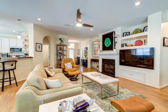 1231 Wild Olive Dr, Mount Pleasant, SC 29464 - living area with arched walkways, a ceiling fan, light wood-style flooring, a fireplace, and recessed lighting