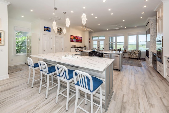 2226 Folly Rd, Charleston, SC 29412 - kitchen with a large island, crown molding, recessed lighting, light wood-style floors, and a breakfast bar