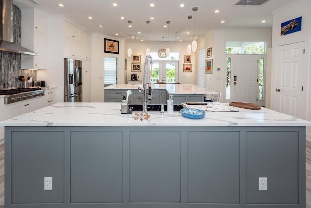 2226 Folly Rd, Charleston, SC 29412 - kitchen featuring wall chimney range hood, a large island with sink, stainless steel appliances, recessed lighting, and white cabinetry