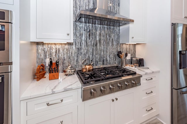 2226 Folly Rd, Charleston, SC 29412 - kitchen featuring wall chimney range hood, stainless steel appliances, backsplash, and white cabinets