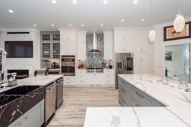 2226 Folly Rd, Charleston, SC 29412 - kitchen with wall chimney range hood, appliances with stainless steel finishes, crown molding, light stone counters, and backsplash