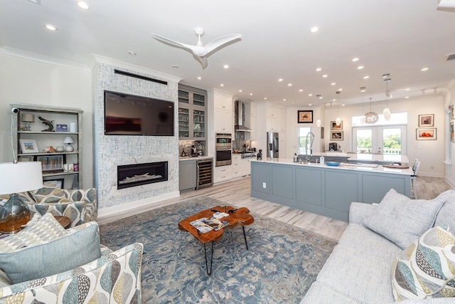 2226 Folly Rd, Charleston, SC 29412 - living room featuring wine cooler, light wood-style flooring, recessed lighting, a fireplace, and crown molding