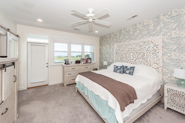 2226 Folly Rd, Charleston, SC 29412 - bedroom featuring wallpapered walls, a barn door, light carpet, a ceiling fan, and recessed lighting