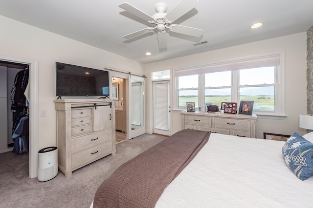 2226 Folly Rd, Charleston, SC 29412 - bedroom featuring a barn door, light carpet, a spacious closet, recessed lighting, and a closet