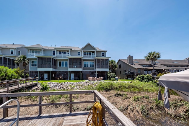 2226 Folly Rd, Charleston, SC 29412 - back of house featuring a sunroom, a residential view, stone siding, and a wooden deck