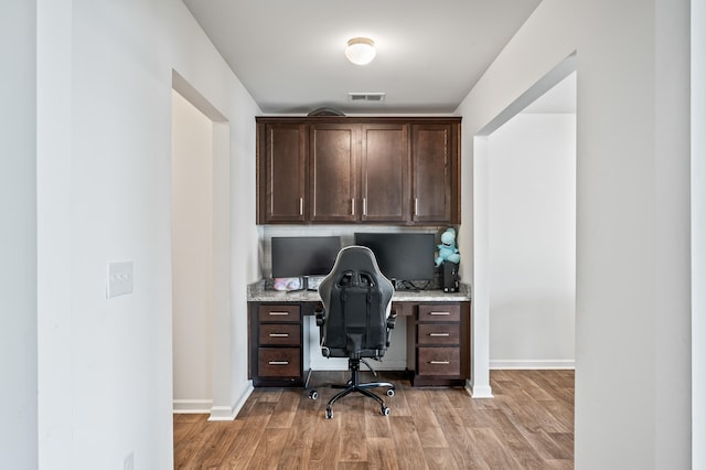 office featuring built in desk and light hardwood / wood-style flooring