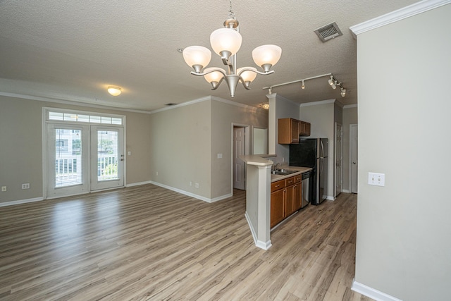 45 Scyamore Ave Unit 623, Charleston, SC 29407 - kitchen featuring light wood finished floors, crown molding, a chandelier, appliances with stainless steel finishes, and light countertops