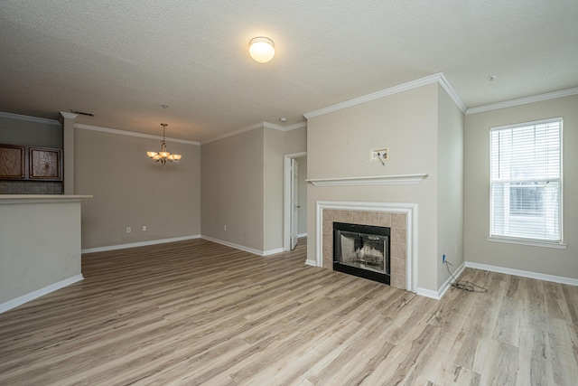 45 Scyamore Ave Unit 623, Charleston, SC 29407 - unfurnished living room with a chandelier, light wood-type flooring, a tile fireplace, a textured ceiling, and ornamental molding