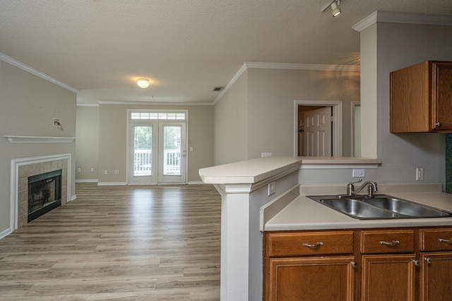 45 Scyamore Ave Unit 623, Charleston, SC 29407 - kitchen with open floor plan, light wood finished floors, a textured ceiling, crown molding, and brown cabinets