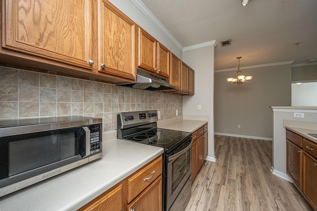 45 Scyamore Ave Unit 623, Charleston, SC 29407 - kitchen with appliances with stainless steel finishes, under cabinet range hood, a chandelier, brown cabinetry, and light wood finished floors