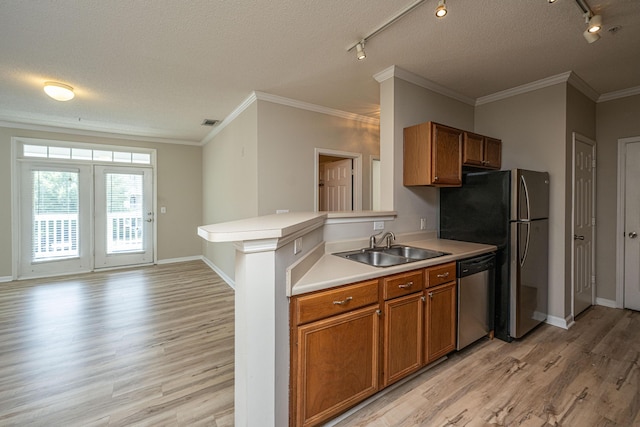45 Scyamore Ave Unit 623, Charleston, SC 29407 - kitchen with appliances with stainless steel finishes, track lighting, brown cabinetry, light wood finished floors, and a textured ceiling