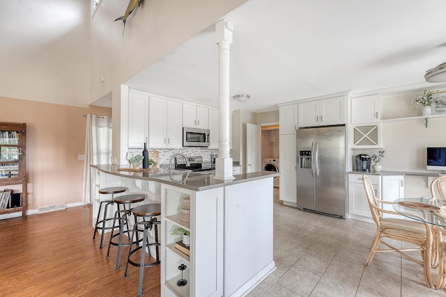 4636 Ashley View Ln, North Charleston, SC 29405 - kitchen with appliances with stainless steel finishes, open shelves, a peninsula, and a breakfast bar