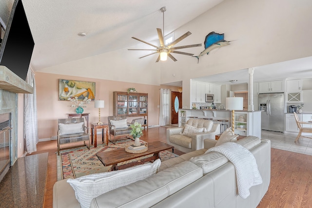 4636 Ashley View Ln, North Charleston, SC 29405 - living room featuring a ceiling fan, ornate columns, high vaulted ceiling, light wood-style flooring, and a fireplace