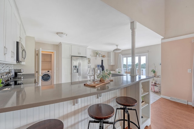 4636 Ashley View Ln, North Charleston, SC 29405 - kitchen featuring stainless steel appliances, washer / dryer, a peninsula, open shelves, and white cabinets