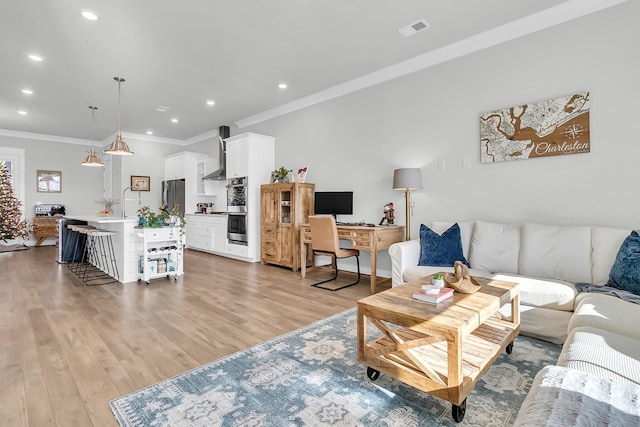 living room with light wood-type flooring and ornamental molding