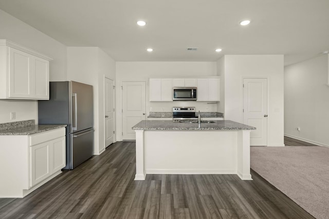 kitchen featuring appliances with stainless steel finishes, white cabinets, visible vents, and light stone countertops