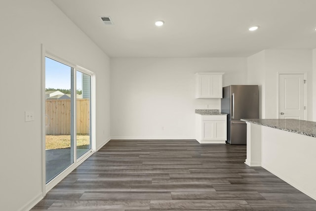 unfurnished dining area with dark wood-type flooring, recessed lighting, visible vents, and baseboards