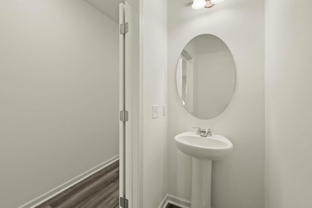 bathroom with wood finished floors and baseboards