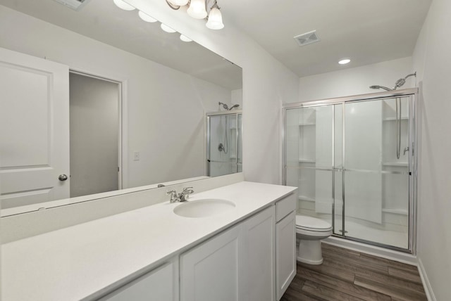 full bathroom featuring toilet, a stall shower, wood finished floors, and visible vents