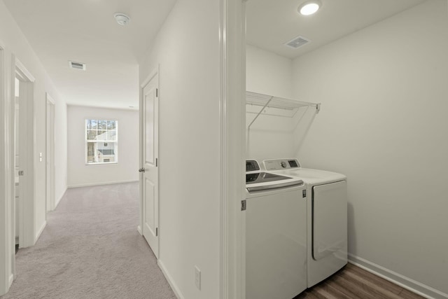 clothes washing area featuring laundry area, visible vents, independent washer and dryer, and baseboards