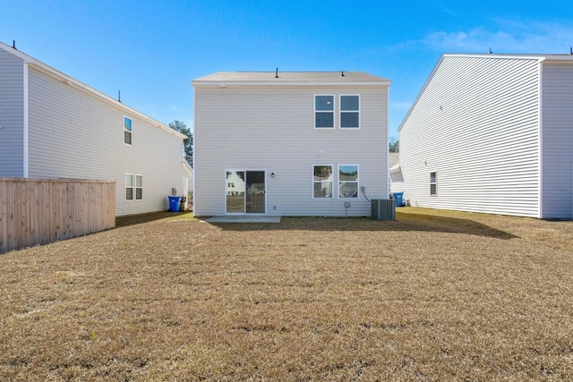 back of property featuring central AC unit and a yard