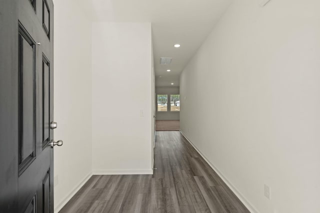 hall with dark wood-style floors, recessed lighting, and baseboards