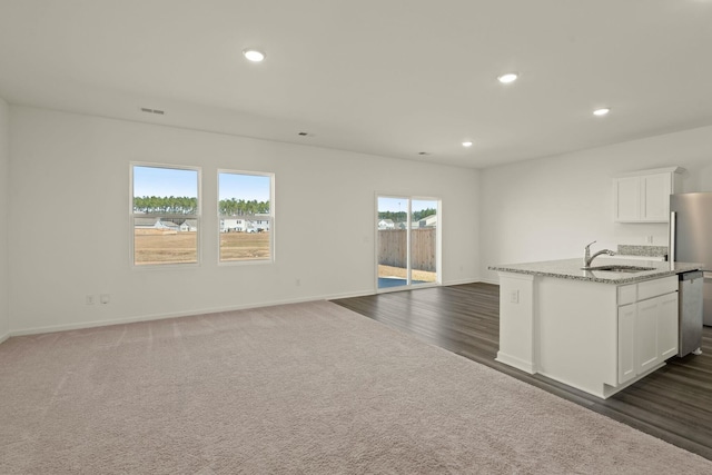 kitchen featuring light stone countertops, stainless steel appliances, a sink, and recessed lighting