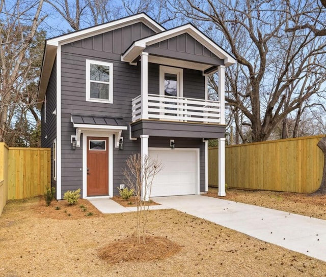 view of front of home with a balcony, a garage, fence, driveway, and board and batten siding