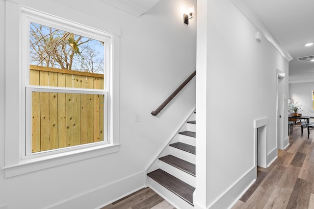 stairway featuring baseboards, visible vents, wood finished floors, and recessed lighting