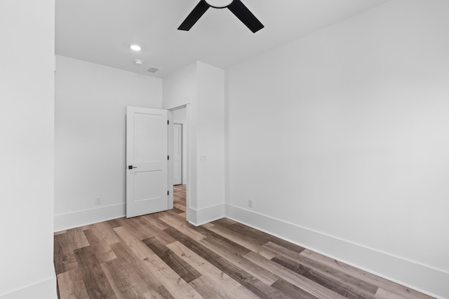 empty room with a ceiling fan, recessed lighting, baseboards, and wood finished floors